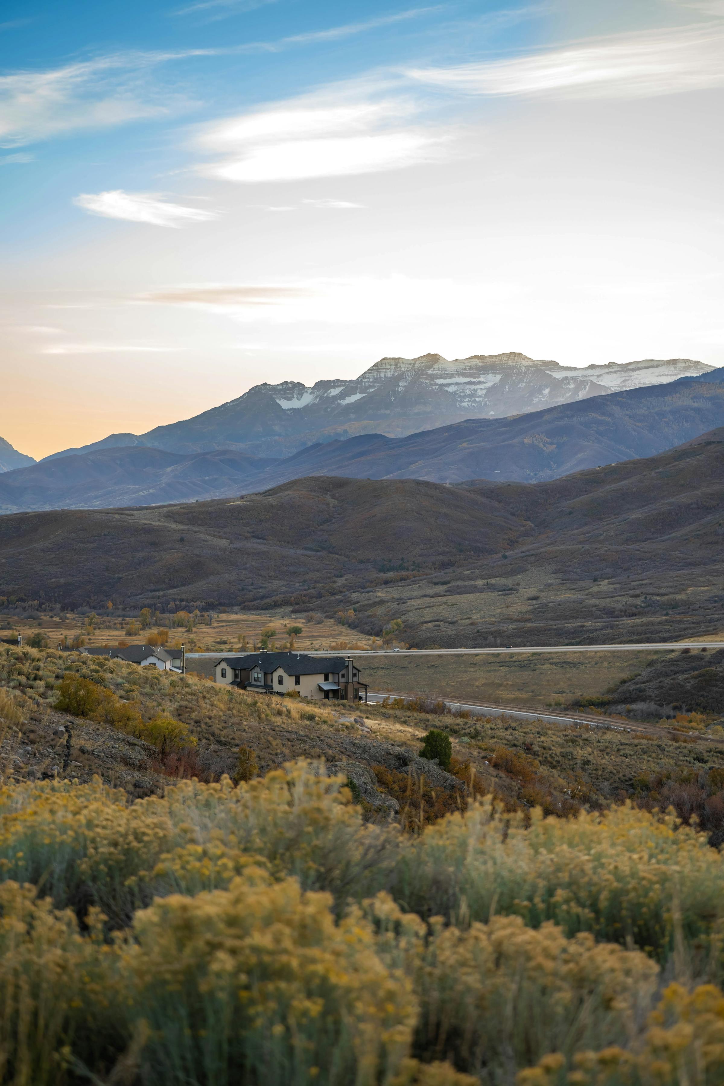 Hillside homes below mountains at sunset